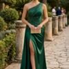 Vestido de cerimónia verde esmeralda comprido de um ombro com brilho subtil e abertura lateral.