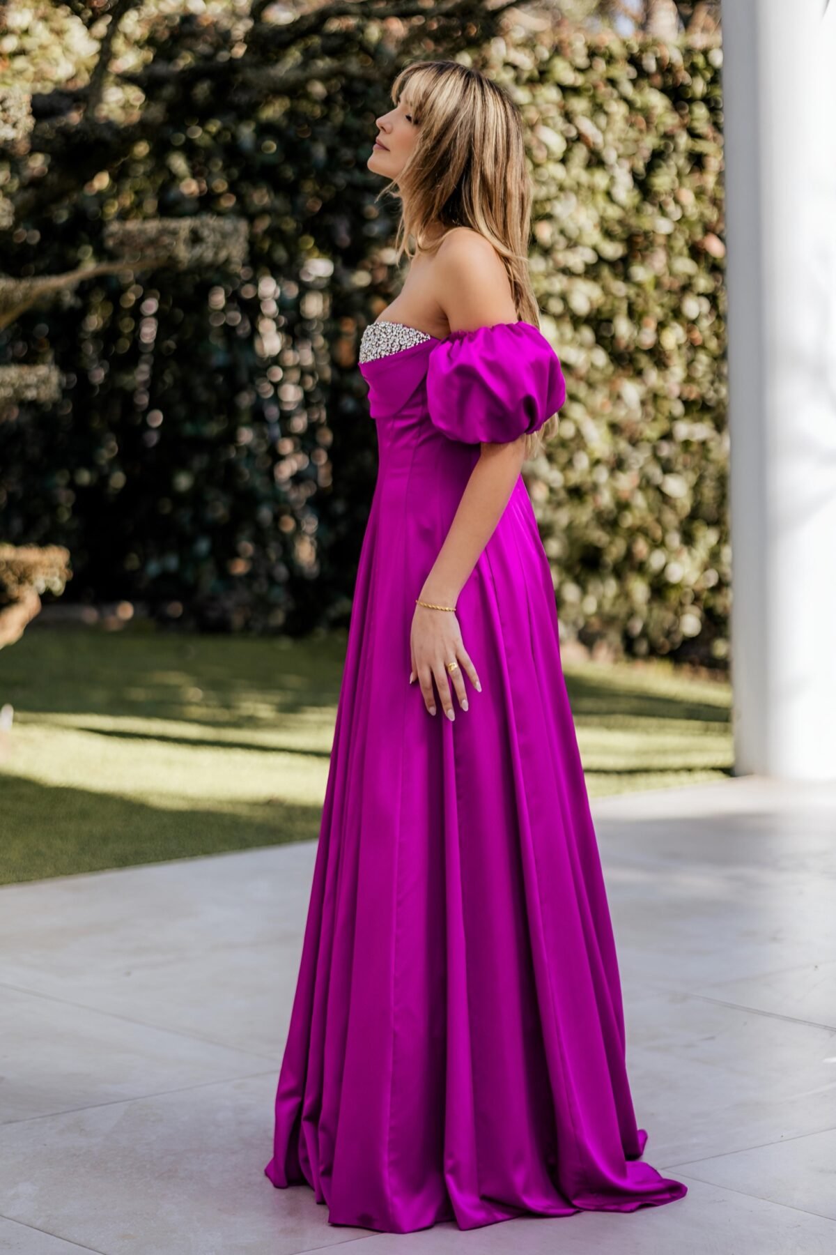 Vestido longo fúcsia com acabamento elegante e brilho subtil no busto.